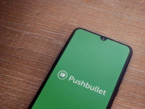 Pushbullet app launch screen on smartphone on wooden background Stock Photos