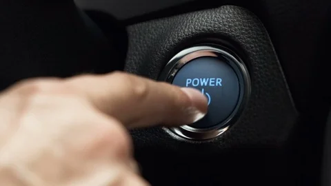 Pushing blue power button to start keyless ignition hybrid car engine Stock Footage 115915068