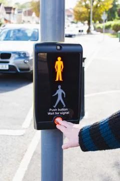 Pushing a button of a signal traffic light at pedestrian crossing Stock Photos