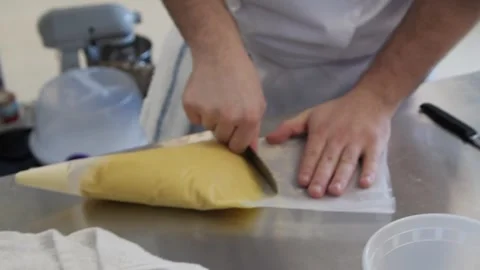 Pushing dough into a plastic bag with a hole in the end Stock Footage 307339960