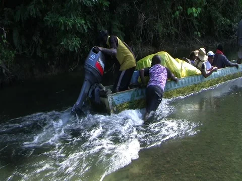 Pushing a dugout canoe up river. Stock Footage 3600357