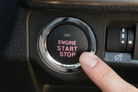 Pushing the engine start stop button of a car Stock Photos