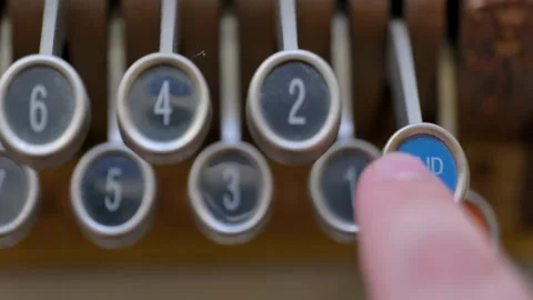 Pushing the paid out  button or latch on an antique cash register Stock Footage 235659718