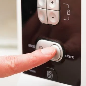 Pushing start button on the microwave oven Stock Photos