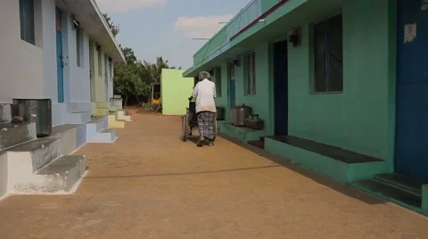 Pushing a wheelchair in India Stock Footage 49323336