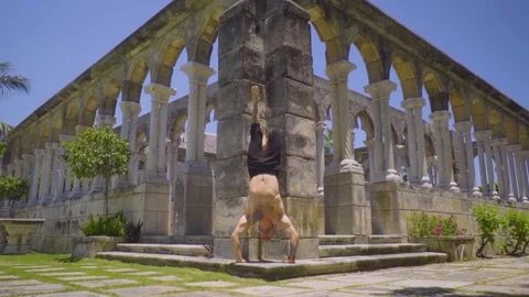 Pushups standing on the hands among the ancient columns Stock Footage 112695889