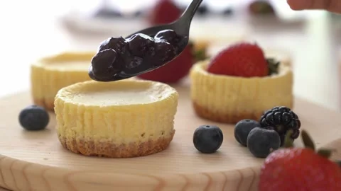 Put blueberry jam on top of mini cheesecake Stock Footage 132229922