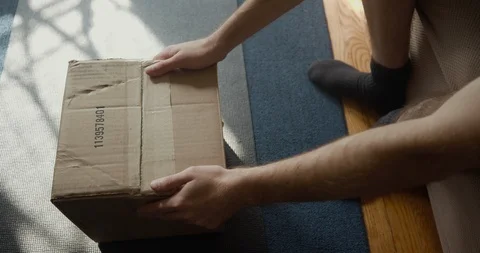 Put box down on floor and take out shoes Stock Footage 119985231