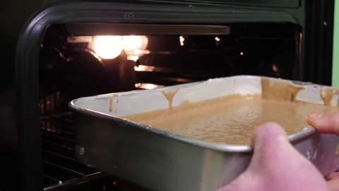 Put cake form in the oven to bake slow motion 4k Stock Footage 85245125
