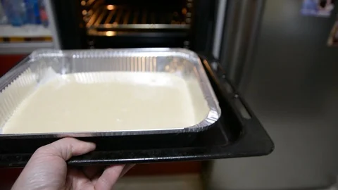 Put cake form in the oven to bake  Vídeos de archivo 100660949