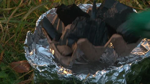 Put charcoal in handmade brazier made of a can of canned food and foil Stock Footage 63209349