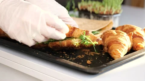 Put a cherry tomato on fresh baked croissant Stock Footage 149328183