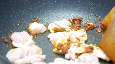 Put chicken into the black teflon pan and stir fried together with spices , c Stock Footage 89498391