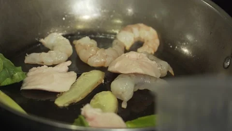 Put chicken fillet in a pan with lime leaves, ginger, lemongrass and shrimp Stock Footage 220728670