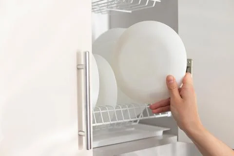Put a clean plate on a shelf in the kitchen. close-up Stock-Fotos