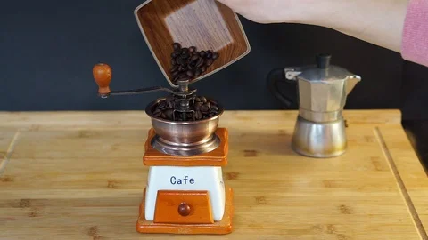 Put coffee beans into the manual coffee grinder Stock Footage 104719438