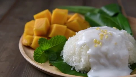 Put Crispy Mung bean on coconut milk and Flavored Sticky Rice with Ripe Mango Stock Footage 172206842