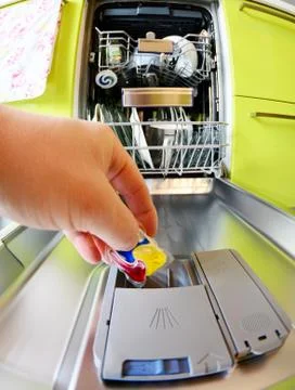 Put detergent tablet into dishwasher. 库存照片