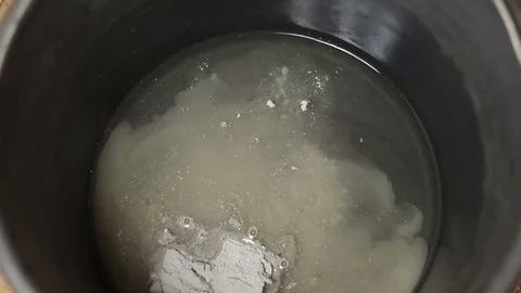 Put dry mortar in a bucket. Construction spatula with dry mix. Stock Footage 129137958