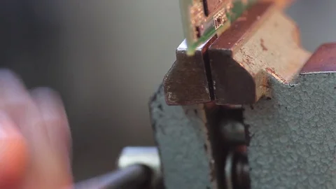 Put electronic circuit in the vise for dismantling Видео 72551297