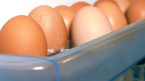 Put a fresh egg in the fridge door, closeup. Stock Footage 108563708