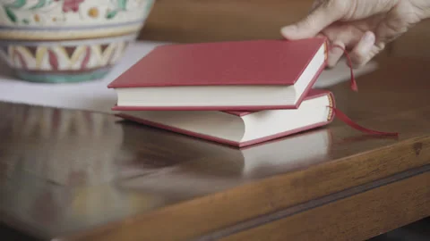 Put hardbacked books on table Stock Footage 320223589