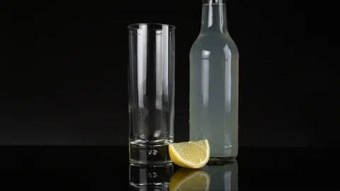 Put ice cubes in a glass an fill it up with Bitter Lemon Stock Footage 123278863
