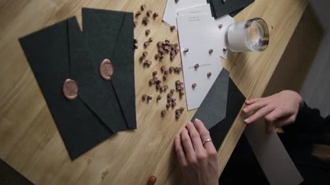 Put the letter in a black envelope. A burning candle. Wooden table. Women's hand Stock Footage 148404834