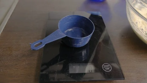 Put milk in a measuring cup on a scale. Stock Footage