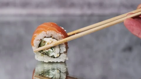 Put One Sushi Roll Using Sticks for Sushi on Mirror Table, Close-Up Stock Footage 252567980
