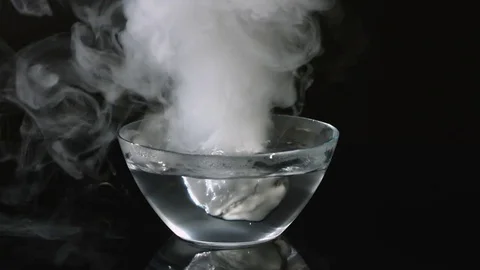 Put piece of dry ice in glass dish with hot water Stock Footage 72965872