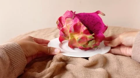 Put a plate of dragon fruit on a brown table Stock Footage 146253290