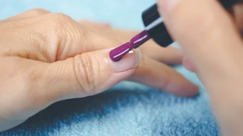 Put purple polish on five hand nails 2 Stock Footage 98739850