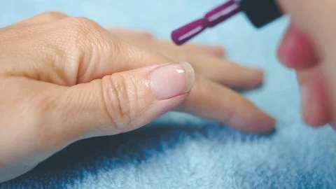 Put purple polish on the thumbnail 1 Stock Footage 98738744