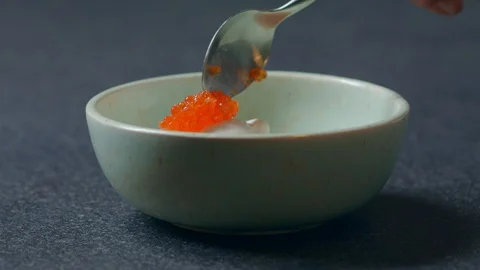 Put red Caviar in a plate with a spoon Healthy food concept Mozzarella Burrata Stock Footage 129573561