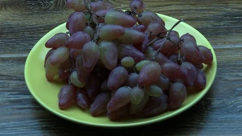 Put red grapes on the yellow plate 스톡 동영상 80107717