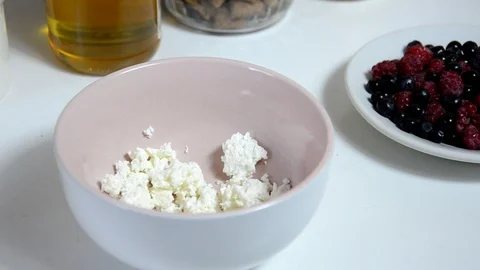 Put Ricotta with fresh berries and honey on pink table. Cottage cheese, curd che 库存影片 115253671