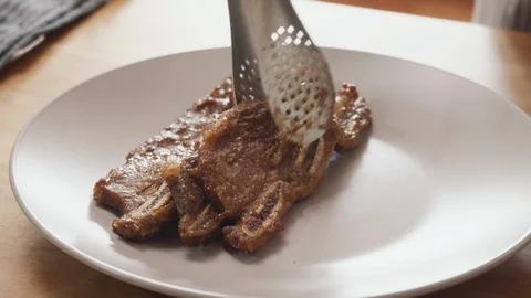 Put ripe beef ribs on the plate. Korean style ribs. Galbi. Stock Footage 115628044