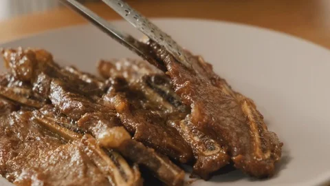 Put ripe beef ribs on the plate. Korean style ribs. Galbi. Stock Footage 115628127