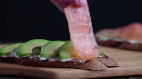 Put  salmon on sandwich with grilled bread avocado cream cheese close  up macro Stock Footage 129000168