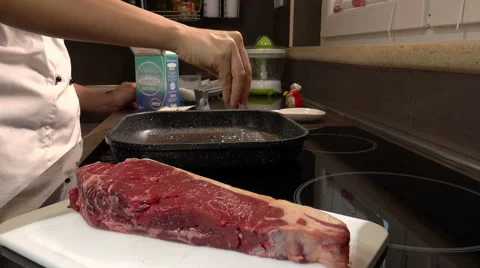 Put salt on the grill to cook a steak: Italian cooking, cooking at home Stock Footage 61355165