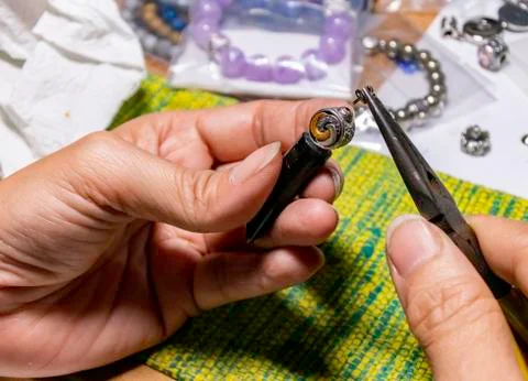 Put silver small ring on top of pendant by pliers Stock-Fotos