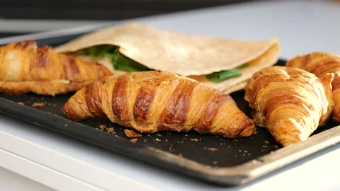 Put a slice of cheese on fresh baked croissant Stock Footage 149327400