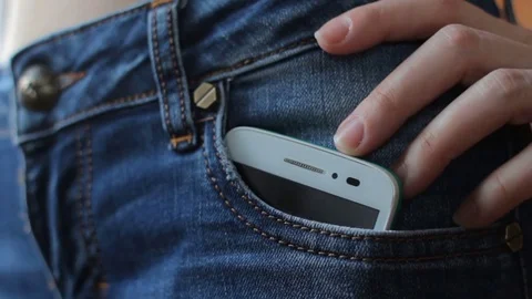 Put smart phone into jeans pocket Stock Footage