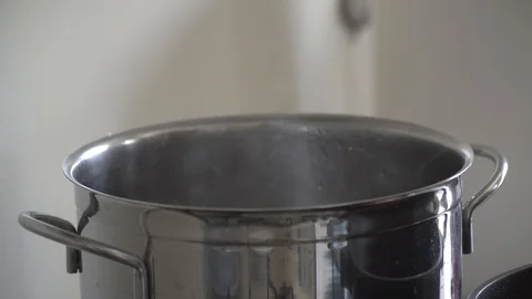Put some pasta in the boiling water pot Stock Footage 128988332