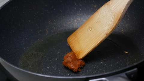 Put the spices , curry paste into the black teflon pan and stir fried togethe Stock Footage 89491434