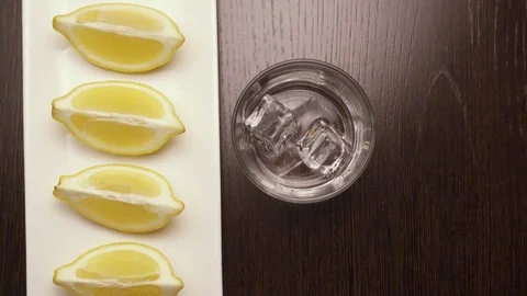 Put on the table a glass with ice cubes, top view Stock Footage 73798884