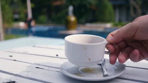 Put on the table by the pool a white cup with fragrant tea. slow motion Stock Footage 87209078