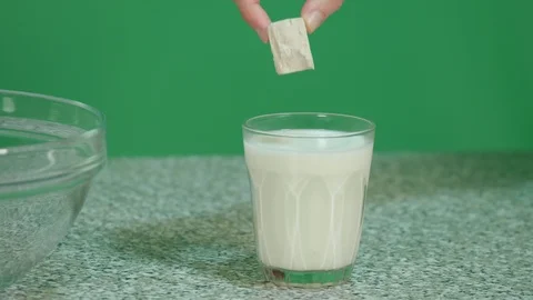 Put the vegetable yeast in the milk to prepare the dough - close up on green Stock Footage 126612837
