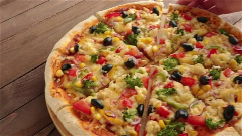Put vegetarian pizza on the table and take one slice close up video Stock Footage 129000193